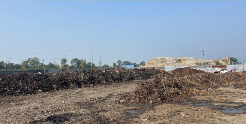 The open-air compost yard with rows of compost piles